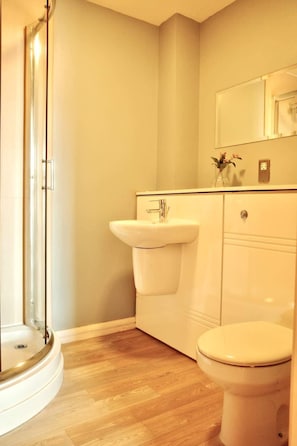 Un baño con ducha, lavamanos e inodoro.