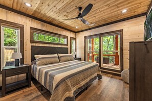 A bedroom with a bed, nightstands, a ceiling fan, and large windows. - Olivers Modern Twist- Cherry Log GA (Cherry Log)
