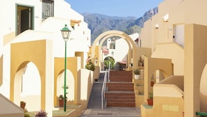 A narrow street with white buildings, a staircase, and potted plants. - Home2Book Stylish Apt Fañabé, BBQ Terrace & Pool (Adeje)