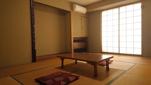 A tatami mat room with a low table and cushions. - Hotel Yuou Onsen  (Kofu)