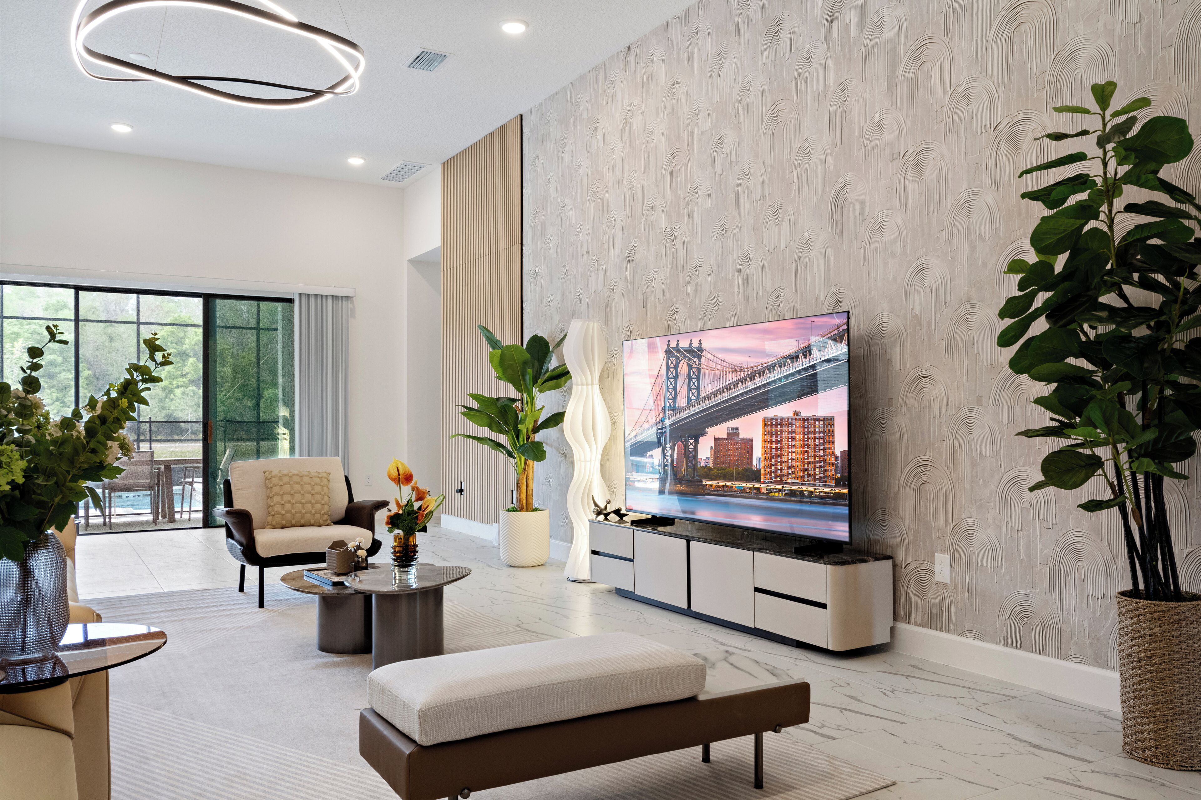 Una sala de estar moderna con un televisor de pantalla plana grande, asientos cómodos, una mesa de centro y una planta en maceta.