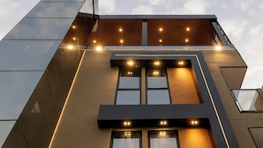 A modern building with a geometric facade, multiple windows, and illuminated entryways. - Aira Hotel (Sobral)