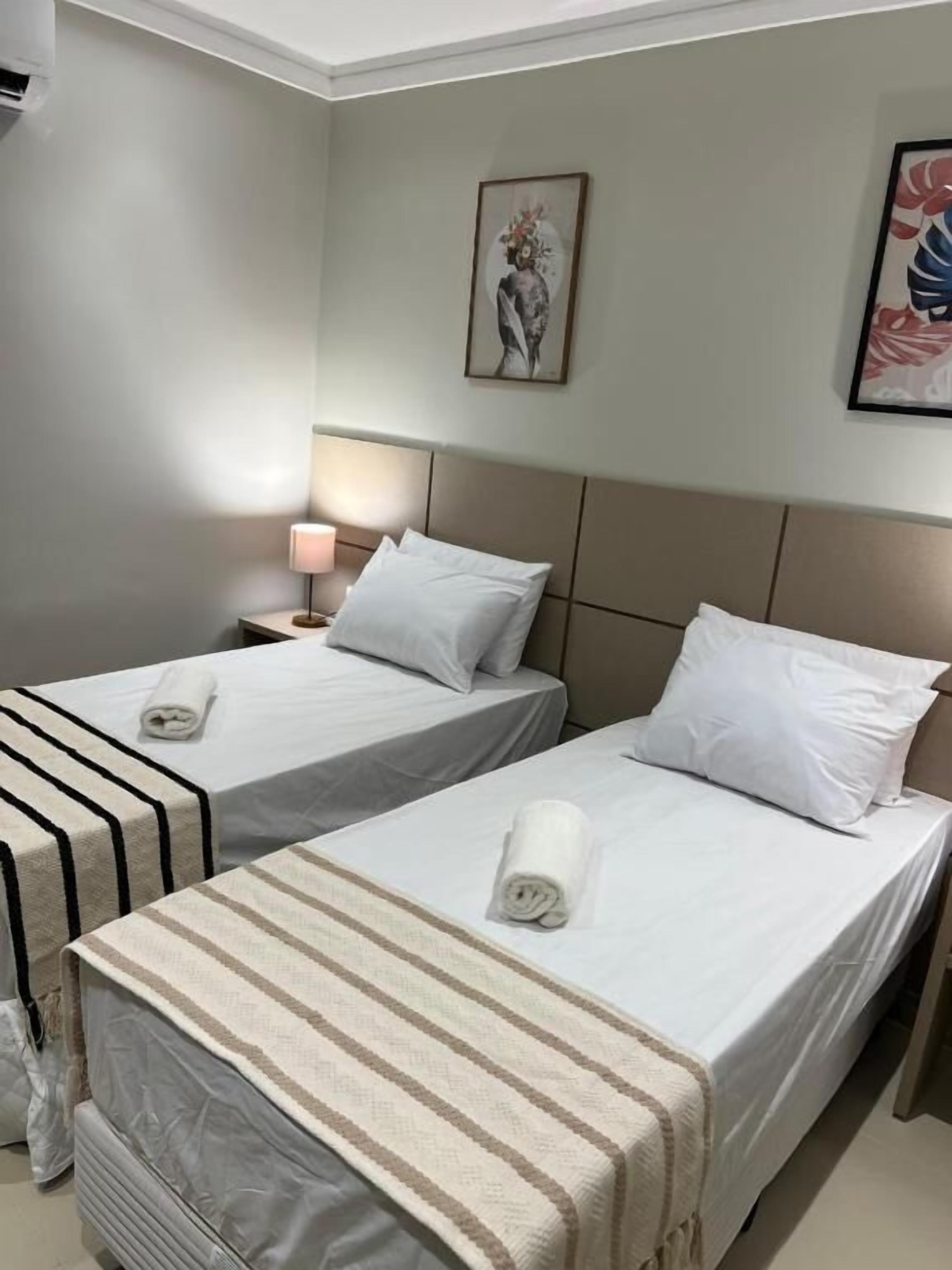 Eenvoudige eenpersoonskamer, 2 eenpersoonsbedden | Een kluis op de kamer, een bureau, een laptopwerkplek