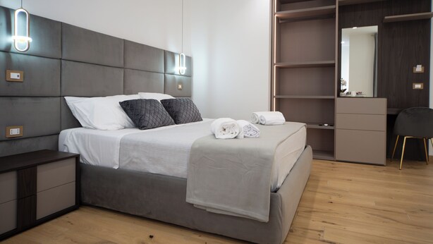 A modern bedroom with a large bed, bedside tables, a wardrobe, and a mirror. - Gold Leaf Sicily "Superior Triple Room" Taormina center (Taormina)