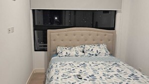Ein Schlafzimmer mit Bett, Fenster und Klimaanlage.