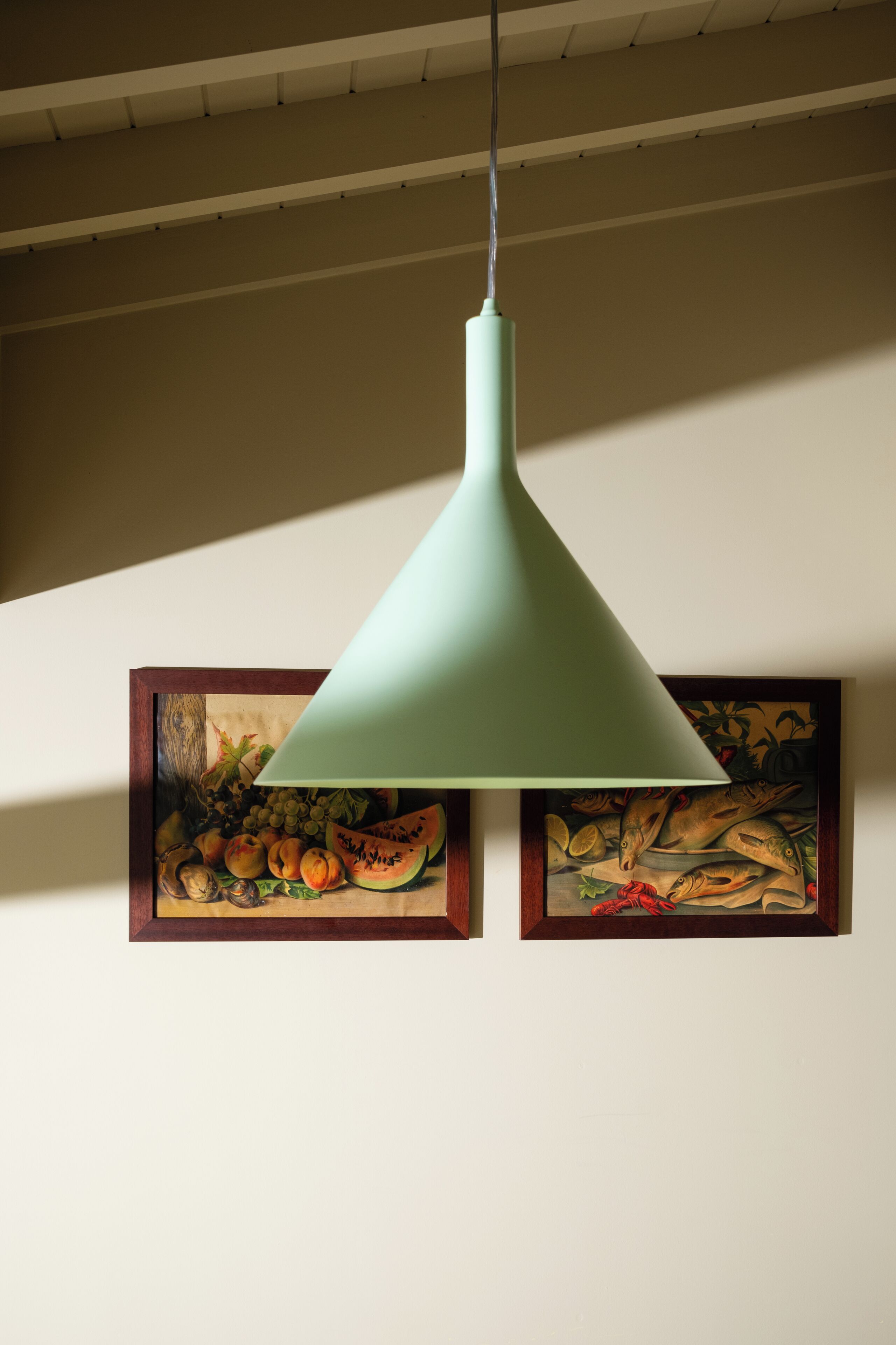 A pendant light with a conical shade hanging from a ceiling.