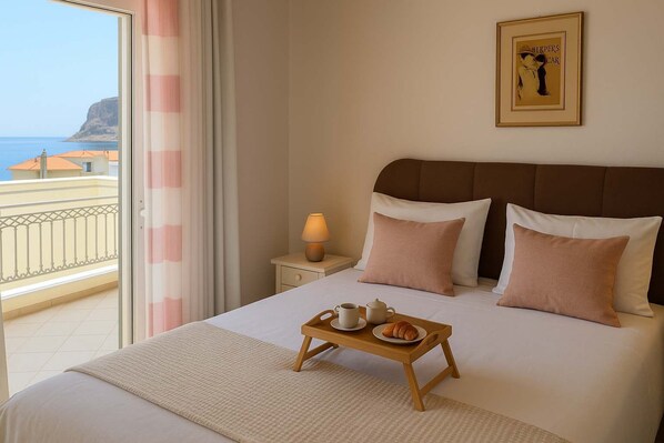A hotel room with a bed, a bedside table with a lamp, a tray with breakfast items, and a view of the sea through a balcony.