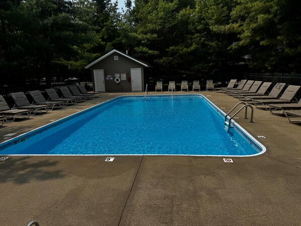 Una piscina rectangular con una torre de salvavidas al fondo.