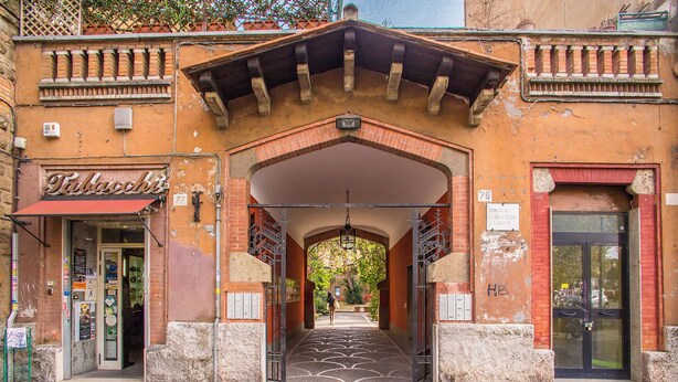 An entrance with a brick archway, a sign reading "Tabacco", and a door with a glass panel. - KNOWING ROME. (Roma)
