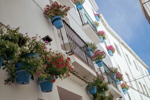 A building with multiple balconies, each adorned with blue flower pots. - Hostal Boutique Tolox Sierra Nieves (Tolox)