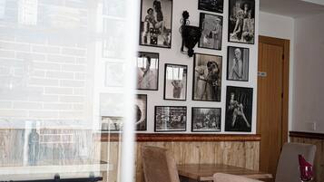 Un restaurante con pared de ladrillo, paneles de madera y una variedad de fotografías blanco y negro en la pared.