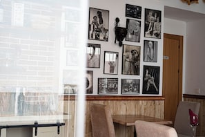Un ristorante con parete in mattoni, rivestimenti in legno e diverse fotografie in bianco e nero alle pareti.