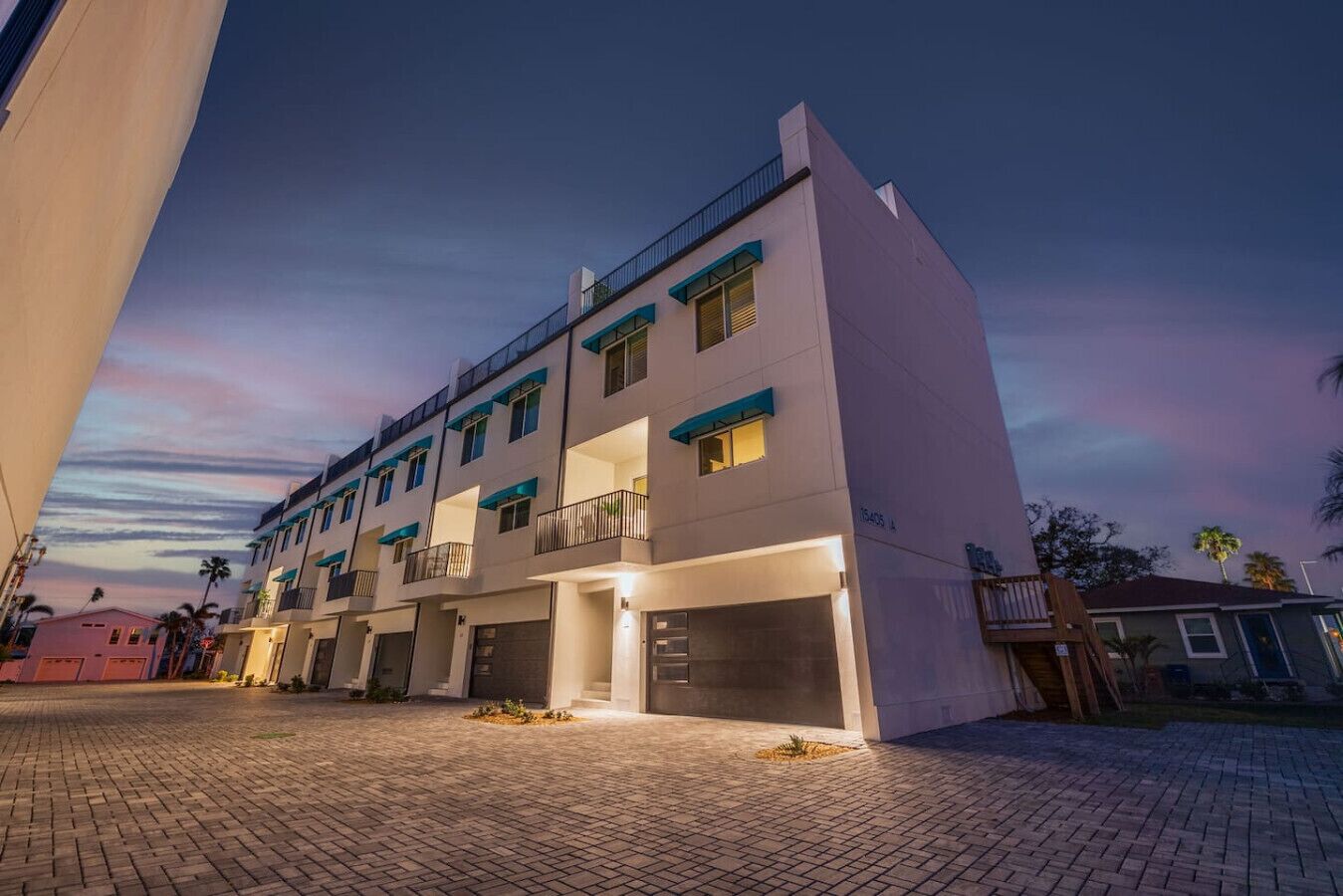 A multi-story hotel with a flat facade, balconies, and a paved courtyard.