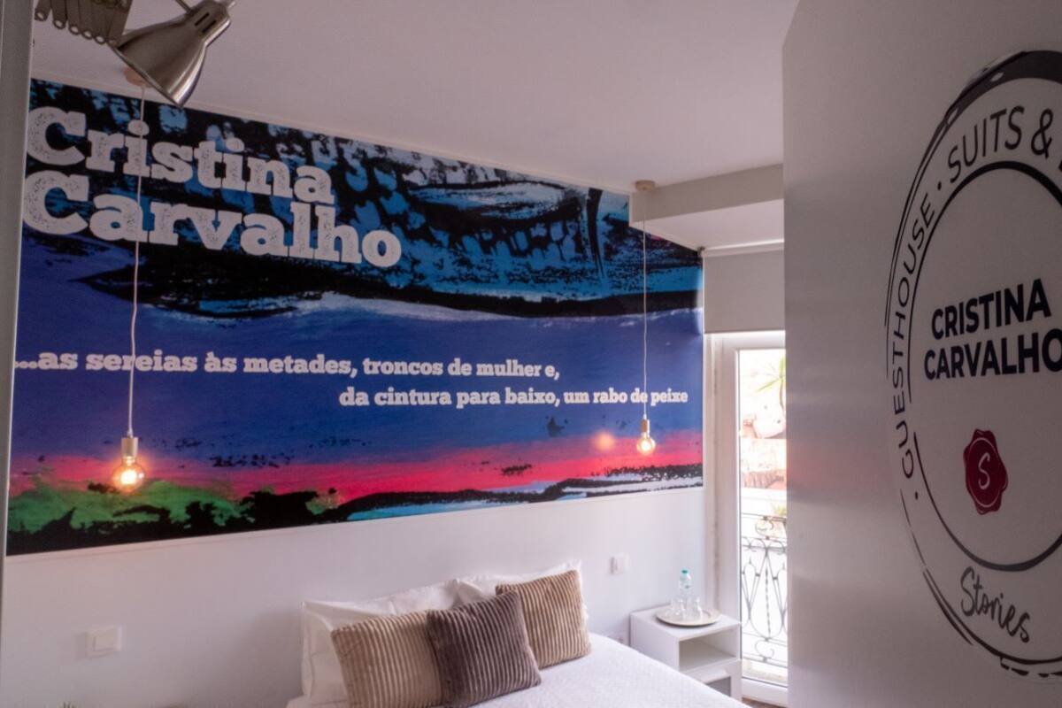 A room with a bed, a wall with a large poster, and a circular sign on the wall.