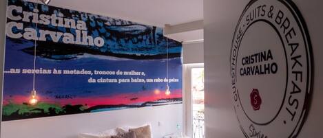 A room with a bed, a wall with a large poster, and a circular sign on the wall.