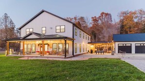 A large two-story house with a covered porch and a garage. - Modern Barndo, Hot Tub, Sauna, Fire Pit, 20 min RRG, Rec Room, Pickleball (Powell County)