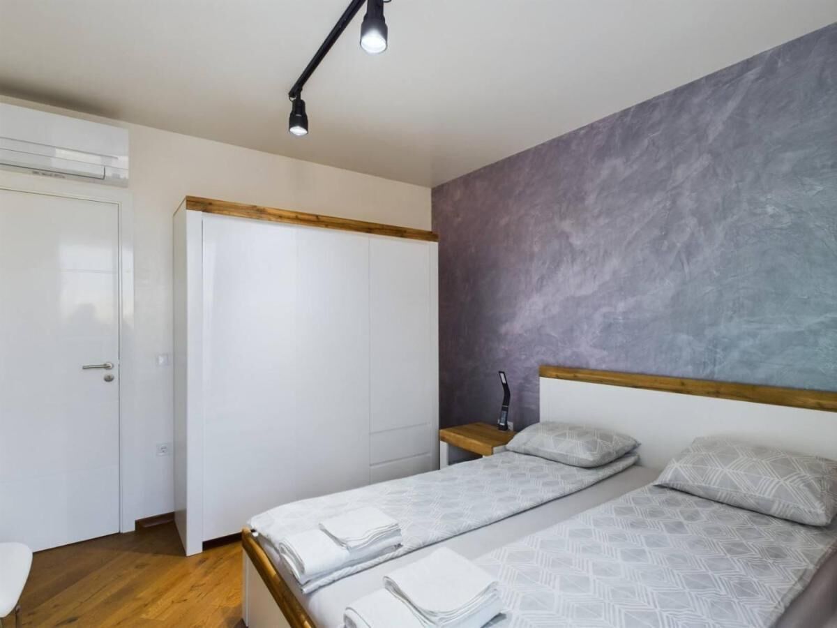 A bedroom with a bed, a wardrobe, and a nightstand.