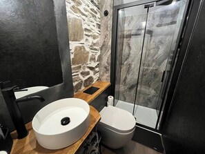 Een douche, handdoeken, zeep, toiletpapier