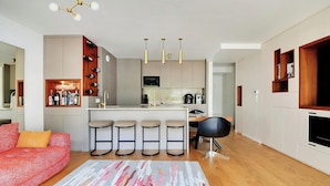 A modern kitchen with a central island, bar stools, and a dining area. - Giulia Prestige, apartment with Terrace Luxury & Comfort at the gates of Paris (Clichy)