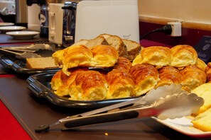 A buffet table with various baked goods including croissants and bread. - Telepostal Congreso (Buenos Aires)