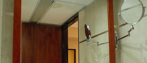 A bathroom with a large mirror, a sink, and a towel rack.