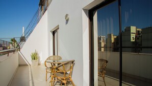 A balcony with wicker furniture, a potted plant, and a glass door leading to the interior. - Telepostal Congreso (Buenos Aires)