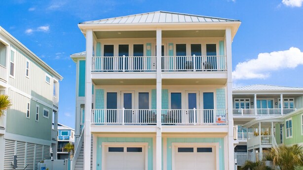 A multi-story building with two balconies and two garages. - BRAND NEW HOME, PRIVATE POOL, partial ocean view  By Williamson Realty (Ocean Isle Beach)