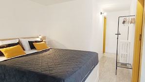 A bedroom with a bed, a bedside table, and a wardrobe.