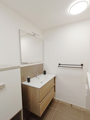 Een haardroger, handdoeken, zeep, toiletpapier