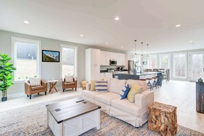 A spacious living room with a white sofa, a coffee table, and a dining area with a kitchen in the background. - Family Getaway 1 min to Bryce Resort! KING Bed! Fire Pit (Mount Jackson)