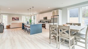 A spacious kitchen with a central island, white cabinetry, and a dining area with wooden chairs. - Family Getaway 1 min to Bryce Resort! KING Bed! Fire Pit (Mount Jackson)