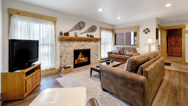 Una sala de estar moderna con chimenea, televisor y asientos cómodos.