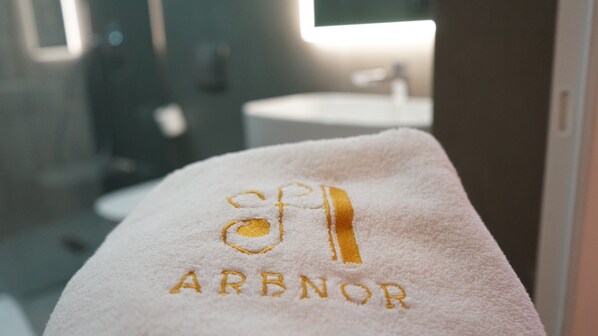 Une serviette blanche avec le texte brodé « SPAR ARBNOR » dans une salle de bain.