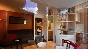 Un intérieur moderne comprenant un coin repas, des lits superposés et une cuisine.