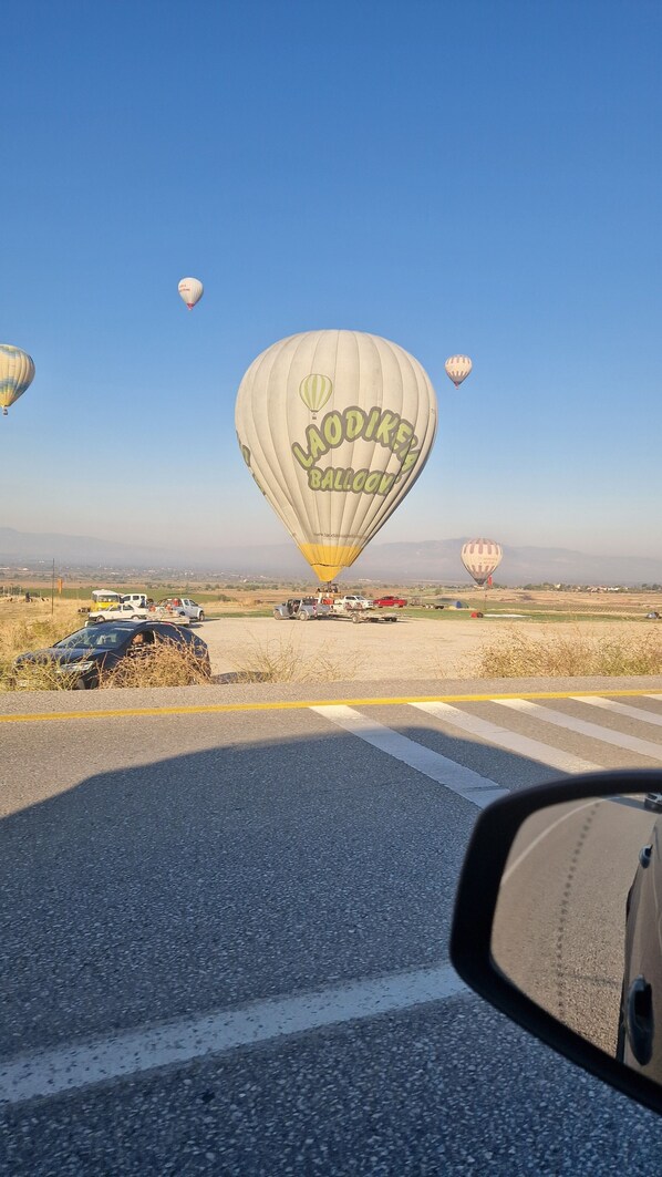 A hot air balloon with the text "LAODIKE BALLOON" in the foreground, with other balloons and vehicles in the background. - Mery Inn Pamukkale (Denizli)