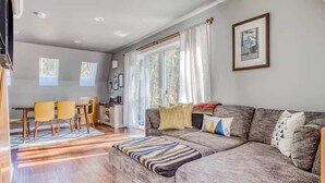 A modern living room with a grey sofa, a striped throw, and a dining area with yellow chairs. - A-Frame of Mind - Secluded Escape  Hot tub (Rhododendron)
