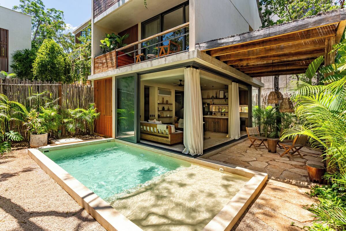 A modern house with a swimming pool, a covered patio, and a balcony with outdoor furniture.