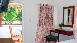 Ein Schlafzimmer mit einem Bett, einem Schreibtisch, einem Stuhl, einem Fernseher und einem Fenster mit Vorhängen.