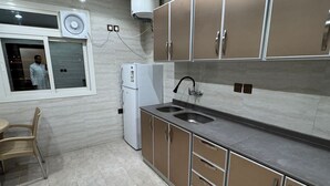 Una cocina moderna con un lavamanos integrado, un refrigerador y armarios.