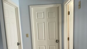 A hallway with a wooden floor, a patterned rug, and white doors. - Private, beautiful and quiet bedroom with private bathroom in county farmhouse.  (Norfolk)