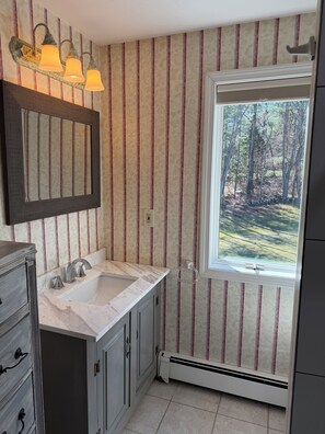 A bathroom with striped wallpaper, a window with a view of trees, a sink, and a mirror. - Private, beautiful and quiet bedroom with private bathroom in county farmhouse.  (Norfolk)