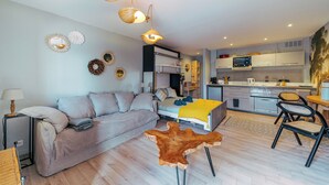 A modern apartment with a living area, a kitchen, and a bedroom.