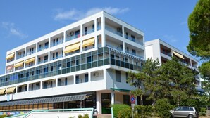 A multi-story hotel with balconies, a covered entrance, and a no parking sign.