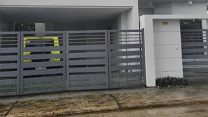 Un edificio moderno a due piani con tetto piatto e un ampio ingresso per garage.