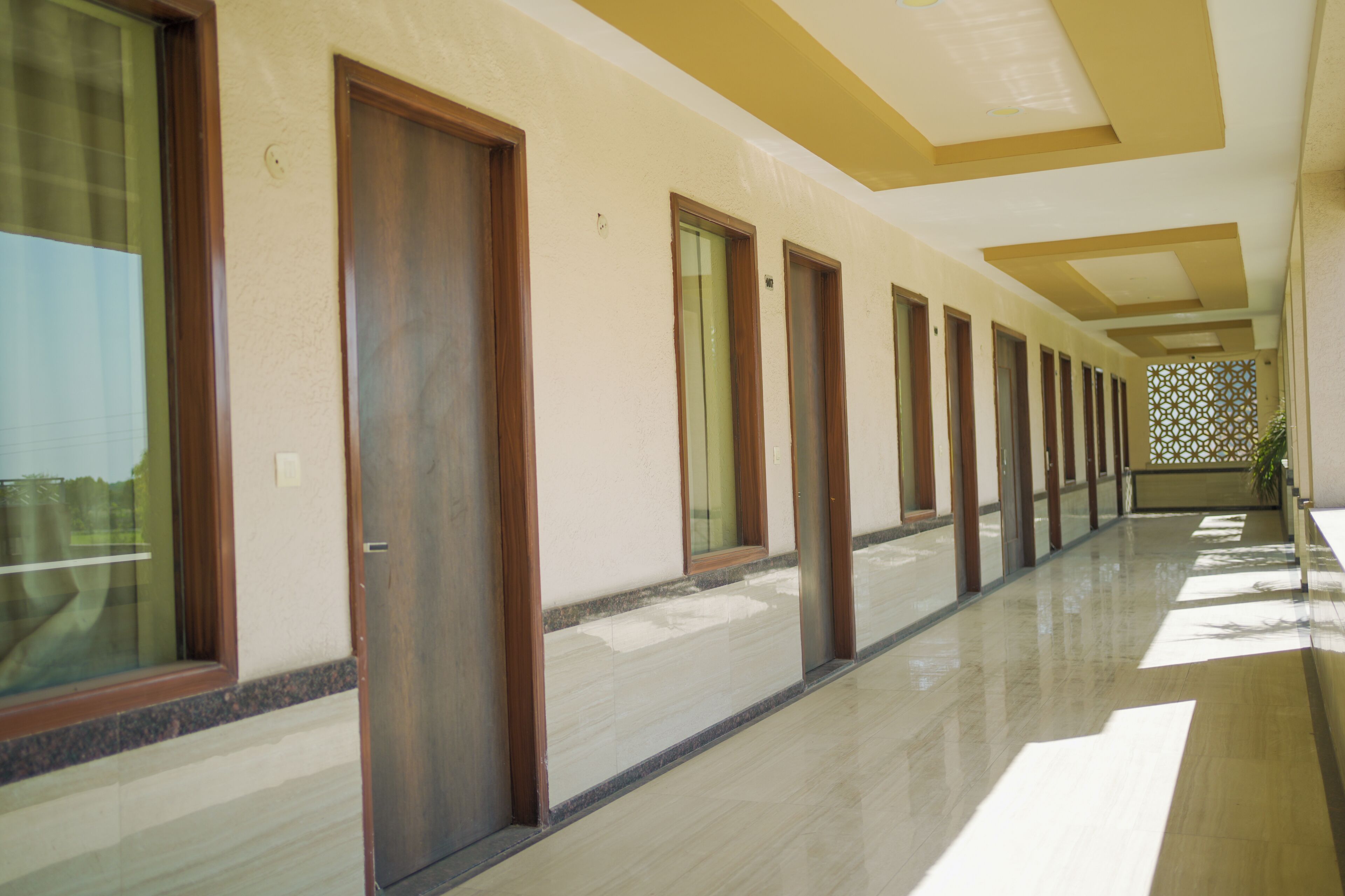 A corridor with doors, a patterned wall, and a tiled floor.