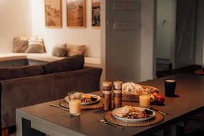 A dining table set with plates of food, glasses of a beverage, and salt and pepper shakers. - Quay-Walk to beach Gas Heated Pool, Spa Trampoline (Blairgowrie)