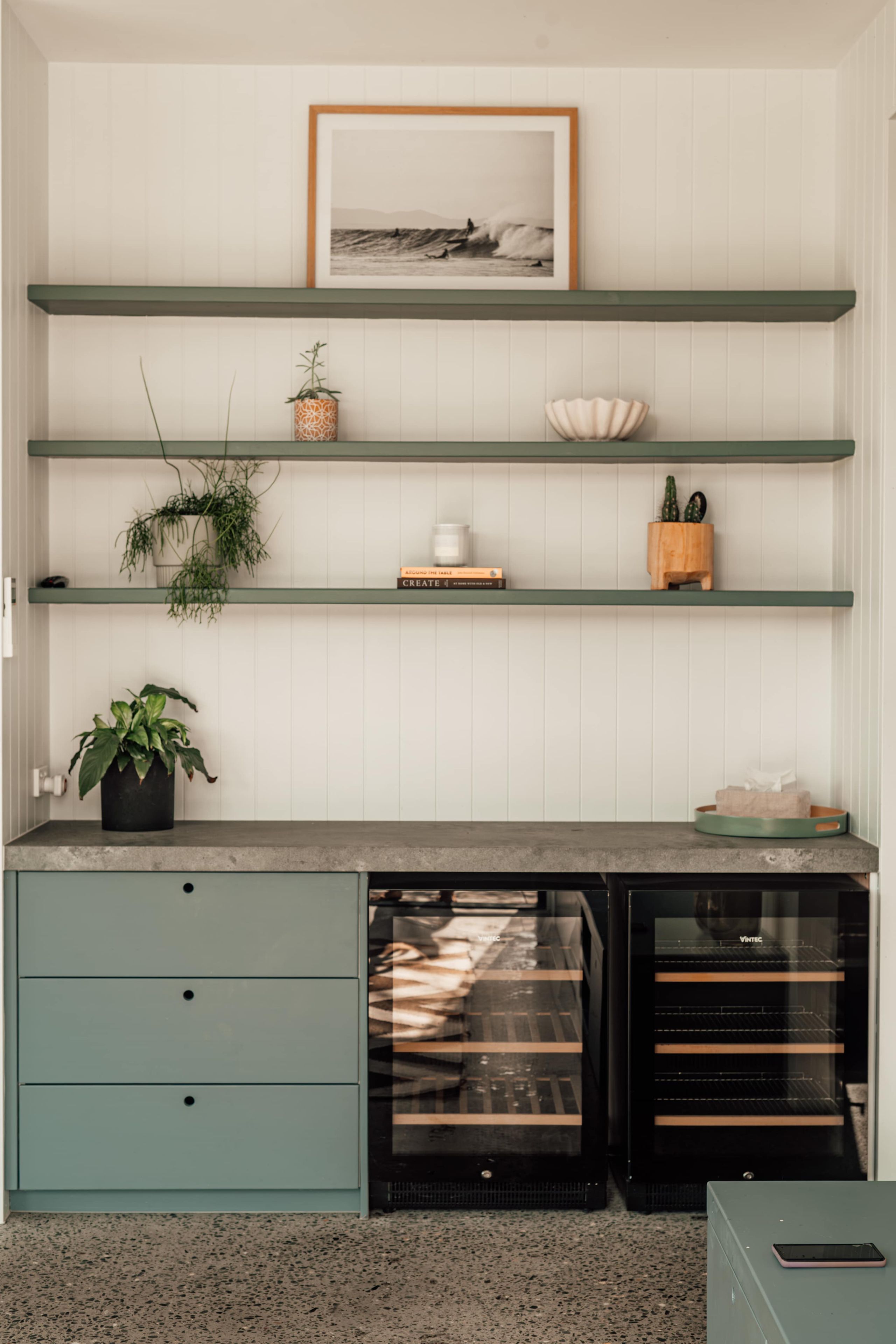 A kitchen with open shelving, a countertop, a dishwasher, and a small refrigerator.