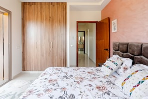 Un dormitorio con cama, un armario de madera y una puerta que da al baño.