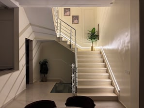 A staircase with a glass landing table and a potted plant.