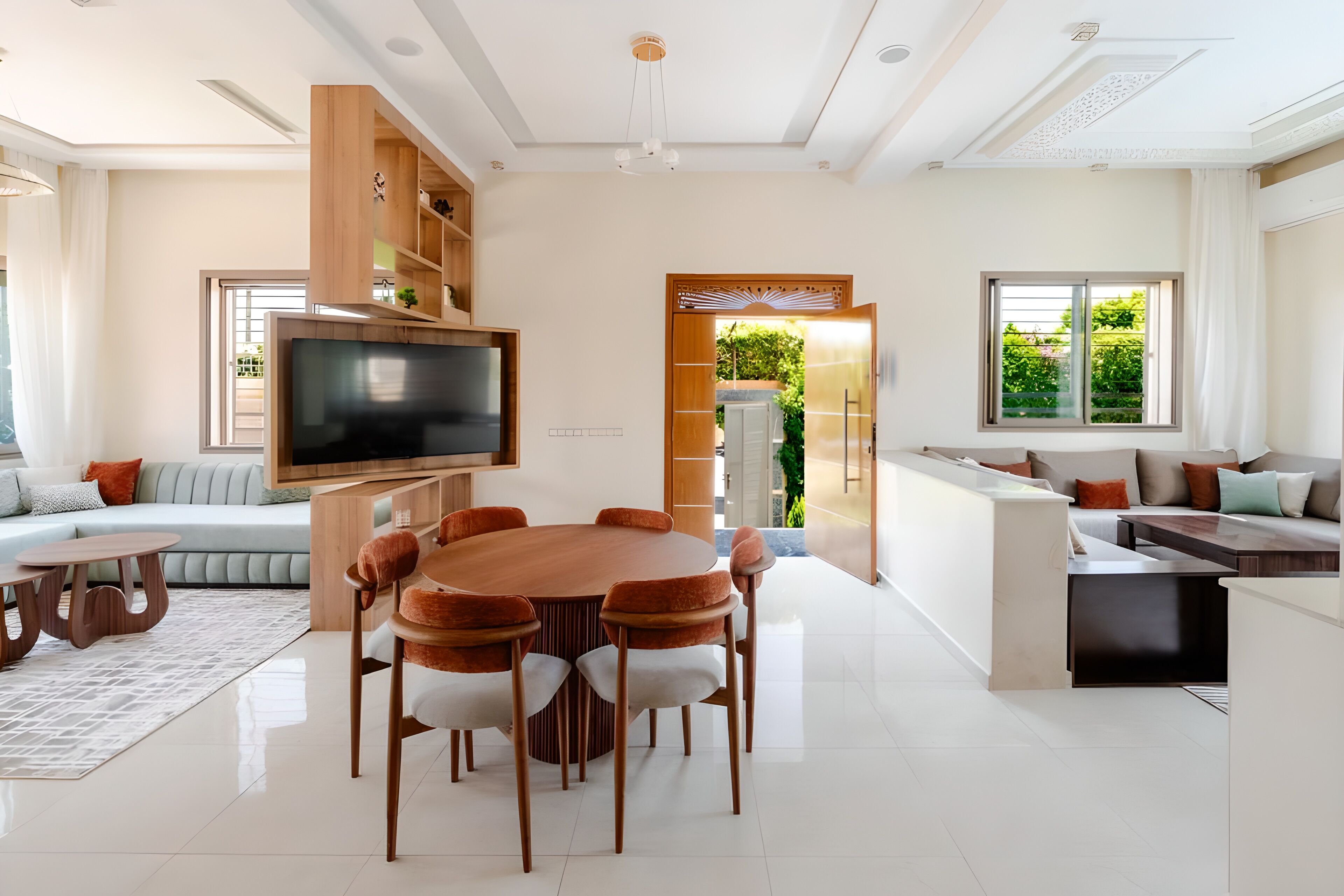 A modern living room with a TV, sofa, dining table, and chairs.